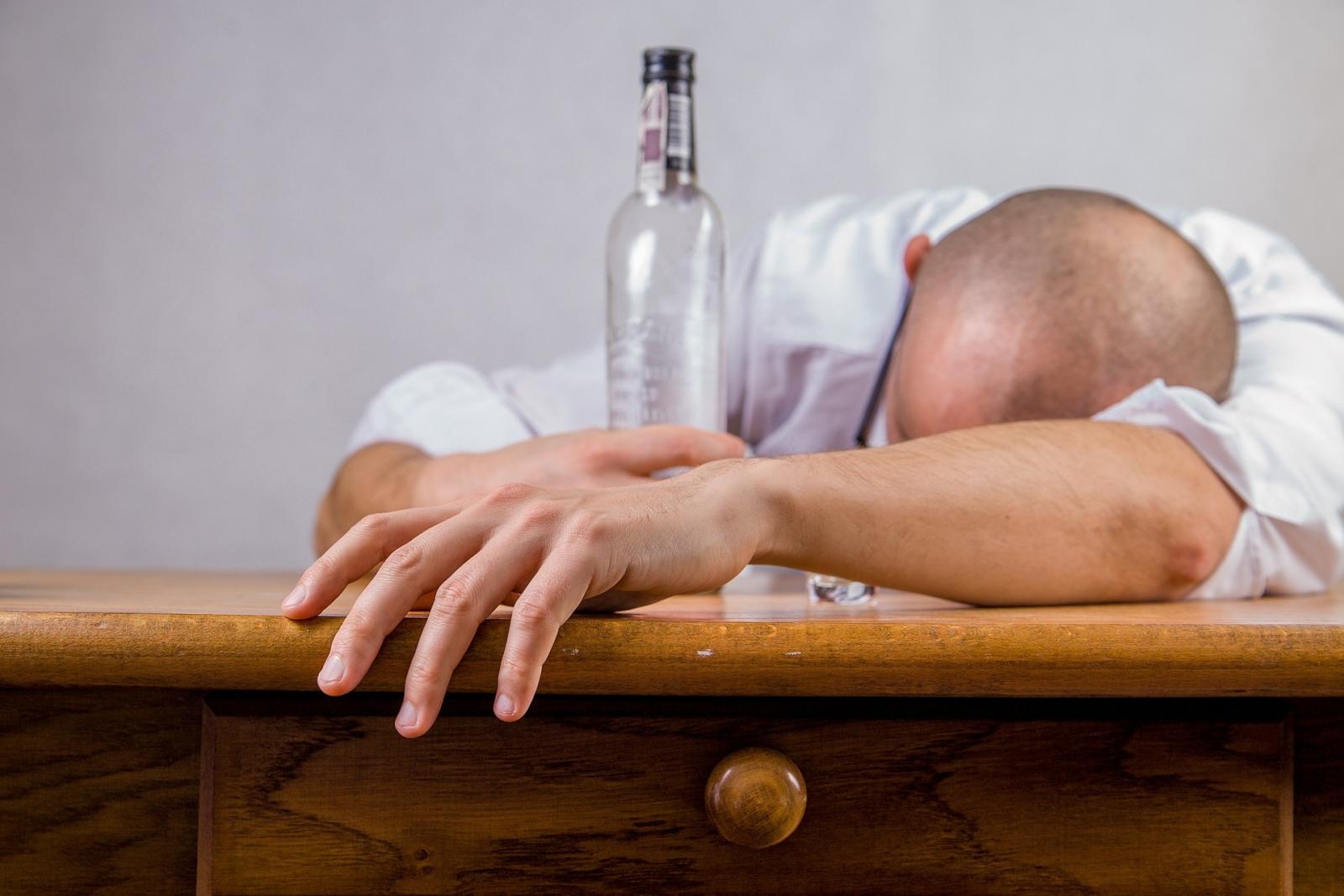 man slumped with bottle